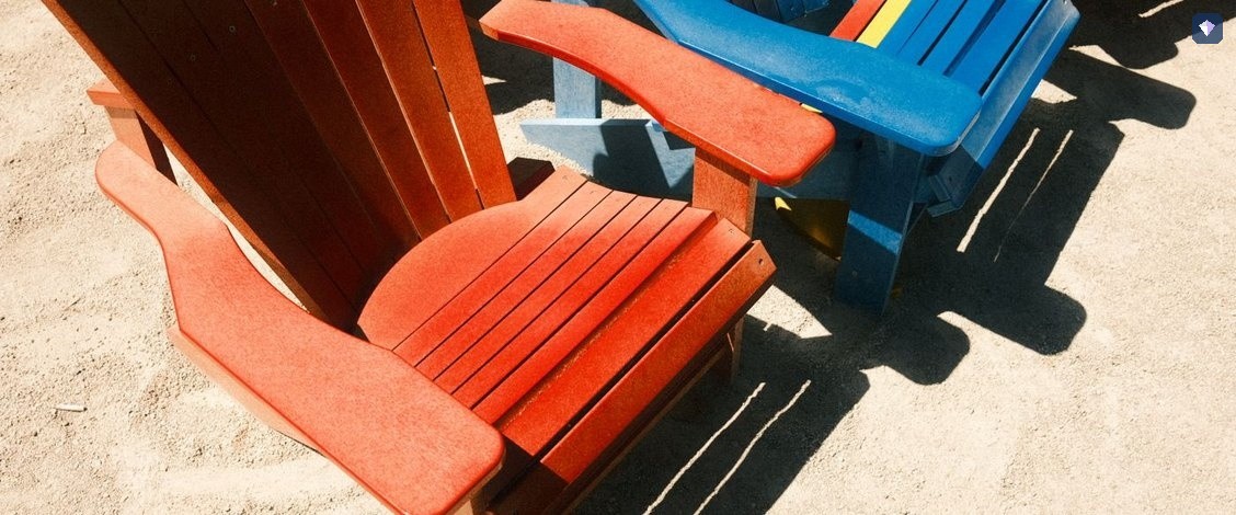 Orange and blue deck chairs standing empty on a sunlit beach