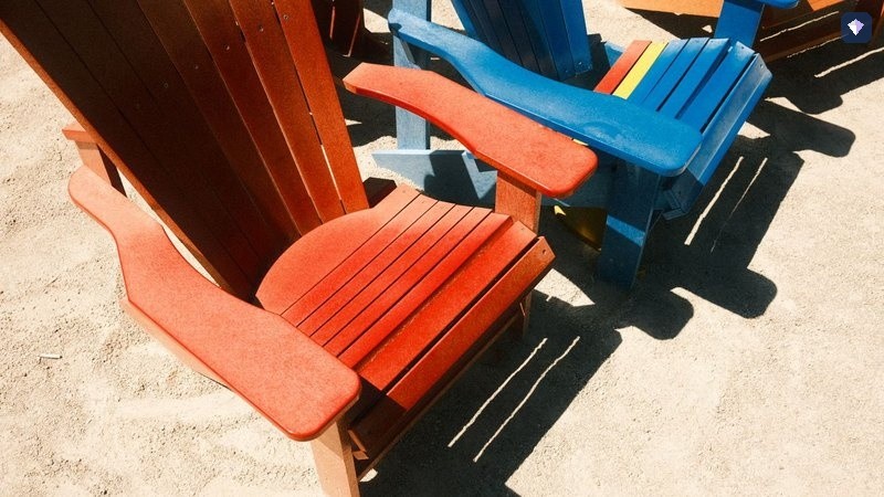 Orange and blue deck chairs standing empty on a sunlit beach