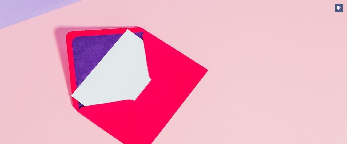 A red envelope and a white card lying unopened on a pink background