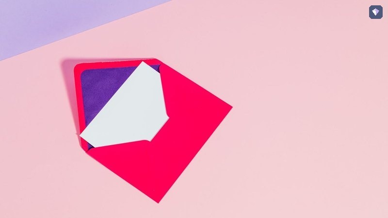 A red envelope and a white card lying unopened on a pink background