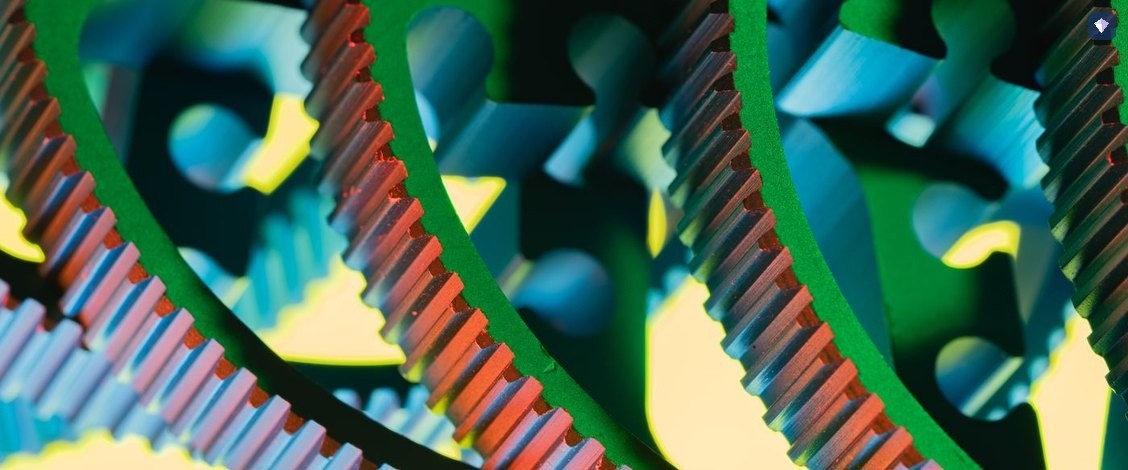 Interlocking cogs in blue, green and red meshing together