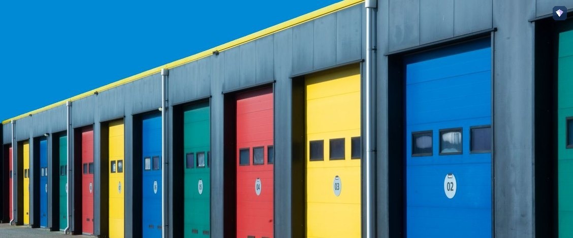 A row of garage doors painted in blue, red, yellow and green