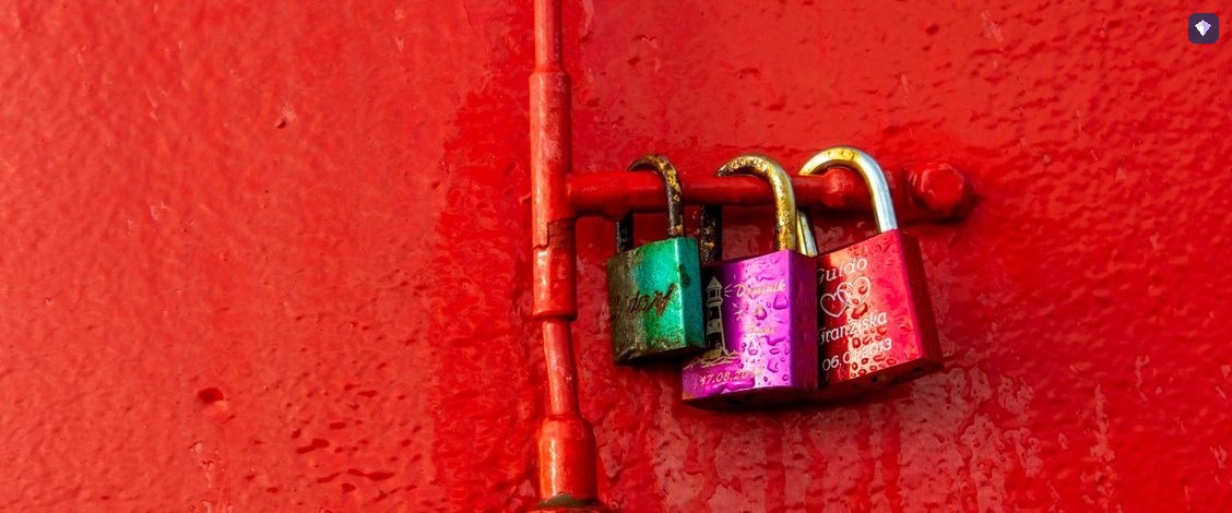 Padlocks fastened to a bright red wall