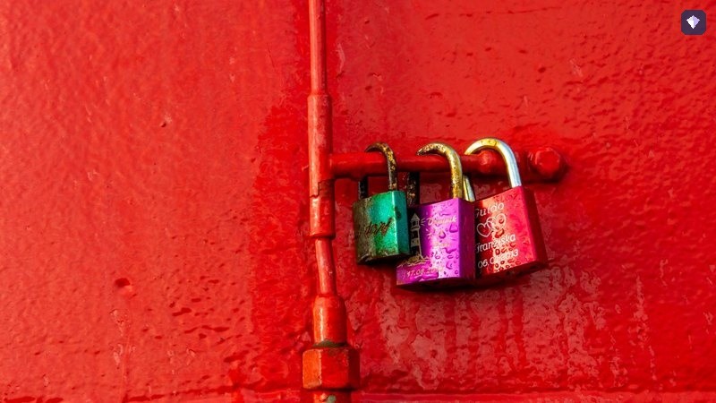 Padlocks fastened to a bright red wall