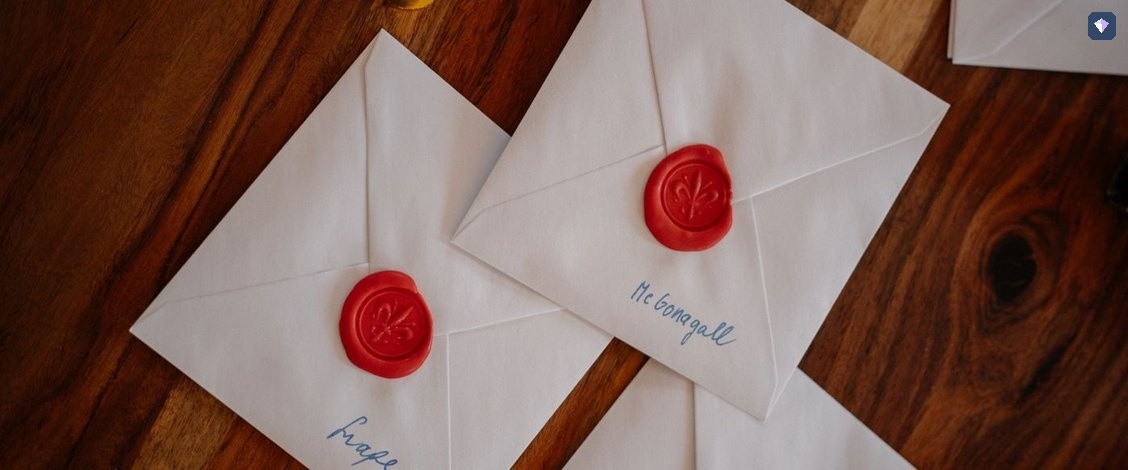 White envelopes closed with red wax seals on a wooden table