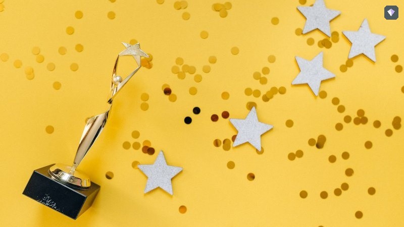 A gold trophy standing among paper stars on a yellow background