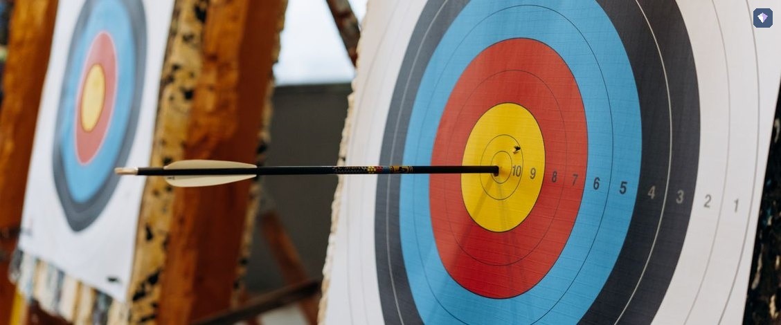 An arrow in the centre of a brightly ringed archery target