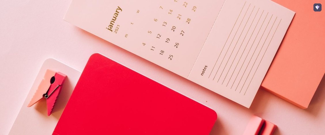 A calendar page lying among brightly coloured notebooks