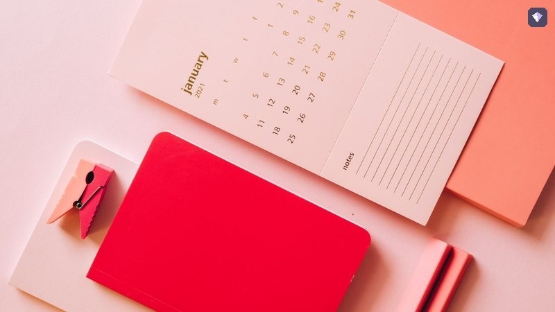 A calendar page lying among brightly coloured notebooks