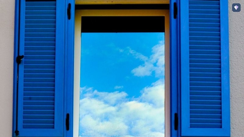 A blue shuttered window standing open to a bright sky