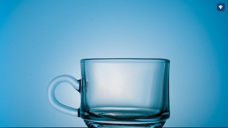 An empty glass cup standing on a blue background