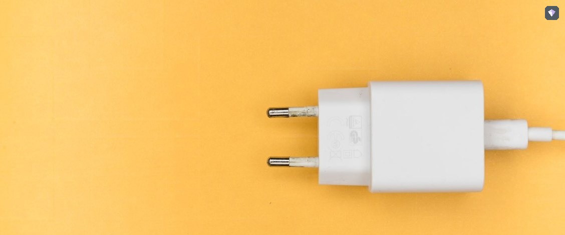 A white plug lying unconnected on a yellow background
