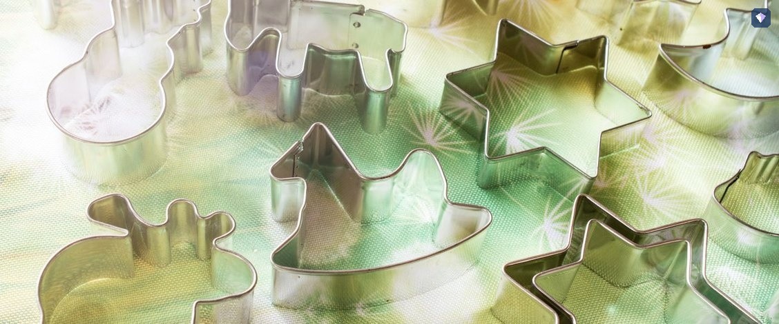 Metal shape cutters laid out together on a coloured surface