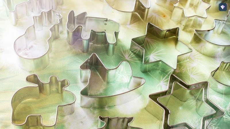 Metal shape cutters laid out together on a coloured surface