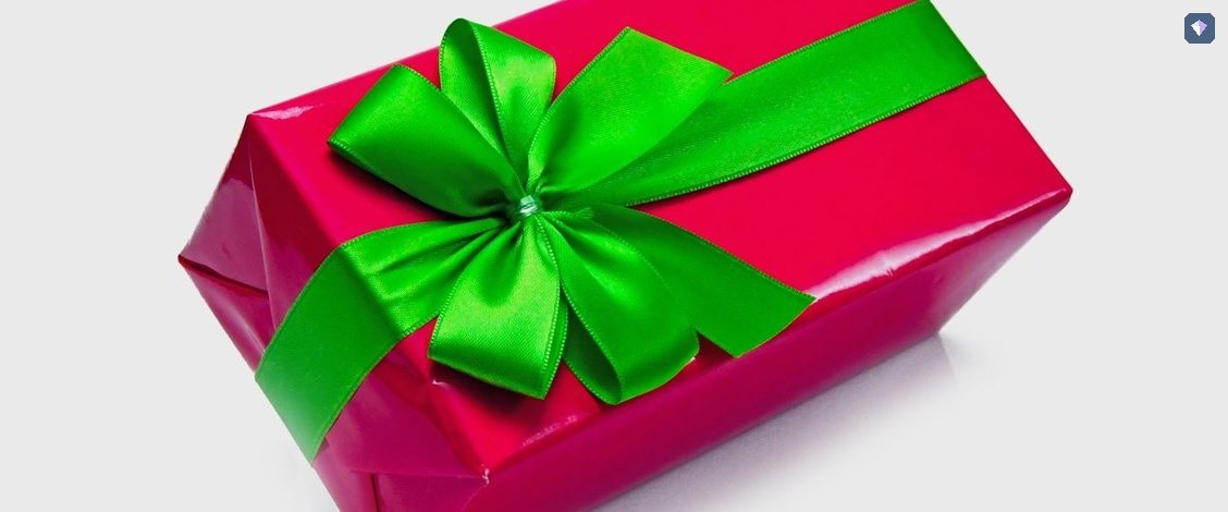 A pink wrapped gift box tied with a green ribbon