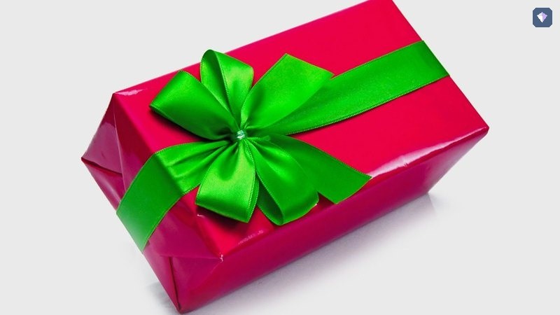 A pink wrapped gift box tied with a green ribbon