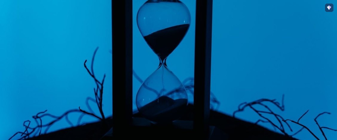 An hourglass standing against a deep blue background
