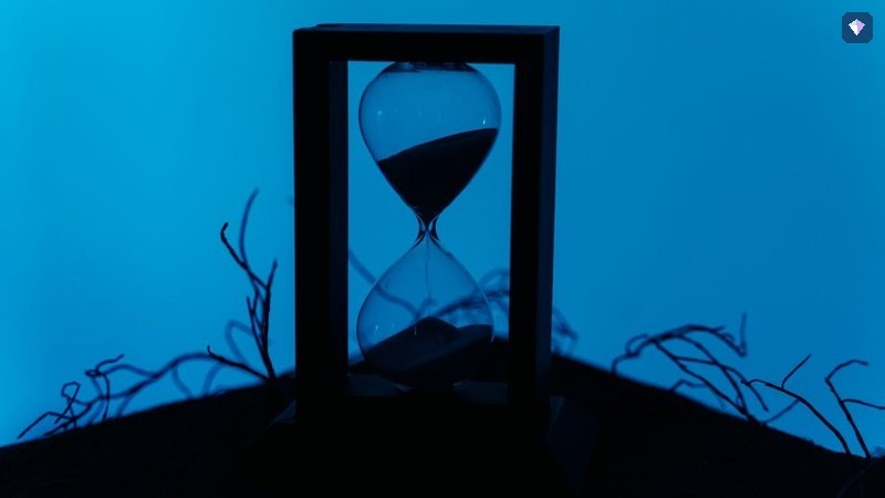 An hourglass standing against a deep blue background