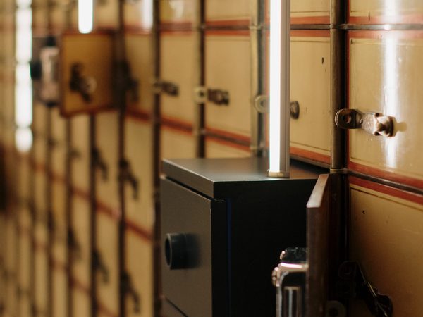 A wall of brass safe deposit boxes with one drawn open