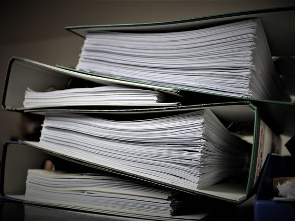 Lever arch files stacked on their sides, the pages of each pressed together
